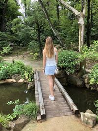 Rear view of woman walking on footbridge