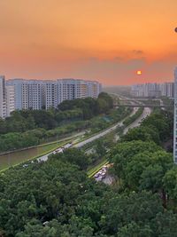 High angle view of trees and buildings against sky during sunset