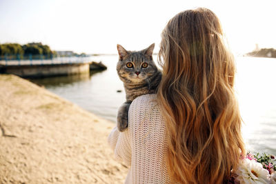 Woman hugging a scottish kitten on a walk