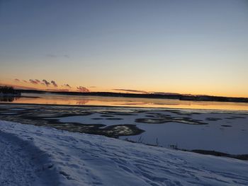 Scenic view of frozen sea against sky during sunset