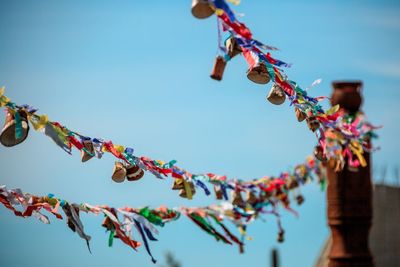 Low angle view of decoration hanging against blue sky