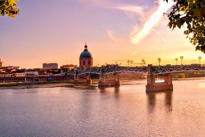 View of river in city at sunset