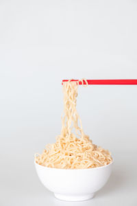 Close-up of pasta in bowl against white background