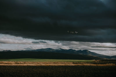 Scenic view of field against cloudy sky