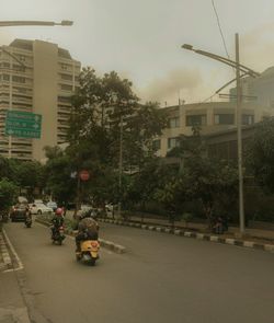 Man on road in city against sky