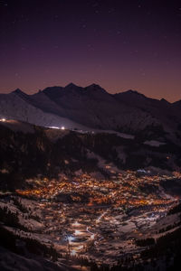 Aerial view of snowcapped mountains against sky at night
