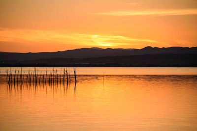 Scenic view of lake against romantic sky at sunset