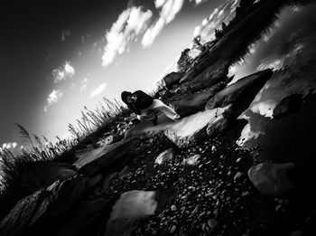 Low angle view of young woman against sky