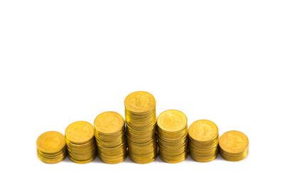Close-up of coins on table against white background