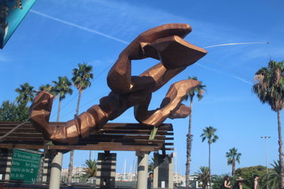 Low angle view of man sculpture against sky