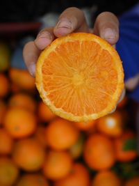 Close-up of hand holding orange