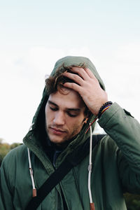 Low angle view of young man standing against clear sky