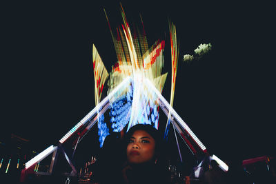 Low angle view of woman looking away at night