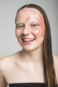 Portrait of a smiling young woman against white background