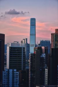 Modern buildings against sky during sunset