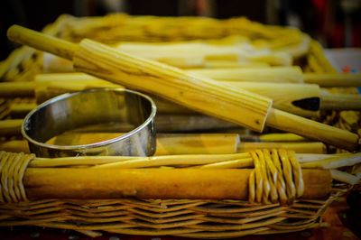 Close-up of bowl and rolling pins in wicker basket