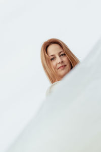 Portrait of young woman against white background