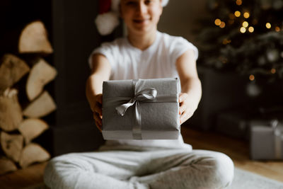 Midsection of boys holding gift box sitting at home