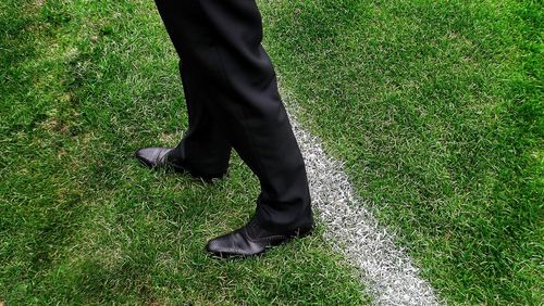 Low section of soccer coach standing on grassy field