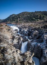 Scenic view of waterfall against clear sky