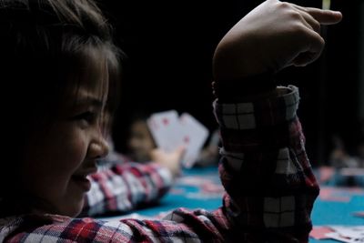 Close-up of cute girl playing cards