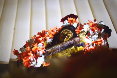 Close-up of god statue with flowers