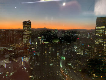 High angle view of illuminated buildings against sky at night