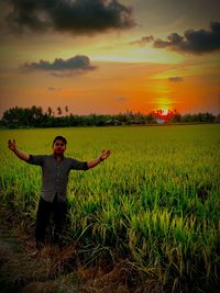 Full length of man with arms raised in field