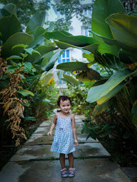 Full length of girl standing against plants