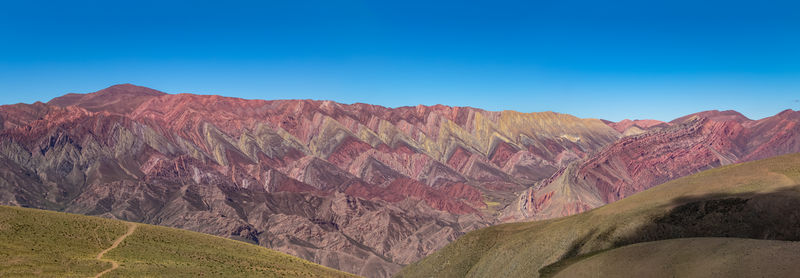 Scenic view of mountains against clear blue sky