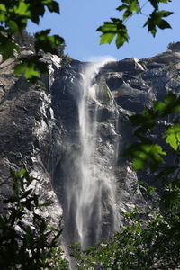 Low angle view of waterfall against sky