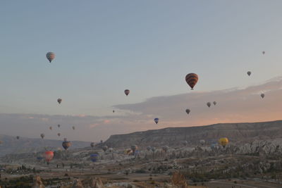 Hot air balloons flying over landscape