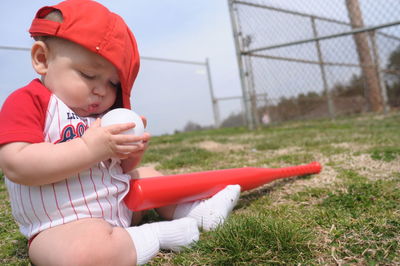 Baby boy playing with baseball at playground