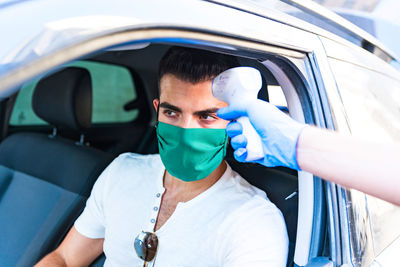 Portrait of young man holding car