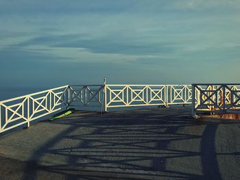 Railing by sea against sky