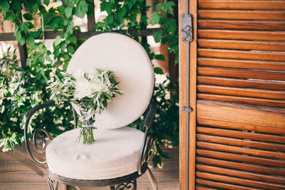 Close-up of flower vase on chair