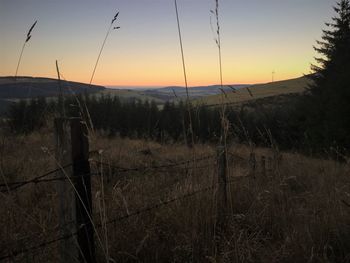 Close-up of farm against sky at sunset