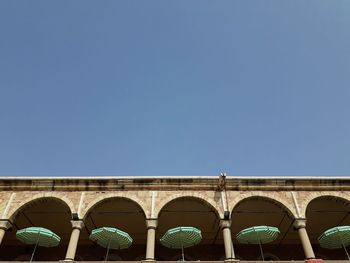 Low angle view of arch bridge against clear blue sky