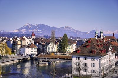 Houses in town against clear blue sky