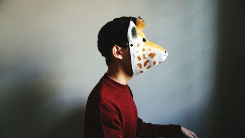Man wearing mask against wall