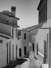 Narrow alley amidst buildings in town against sky