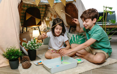 High angle view of friends sitting on potted plant