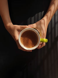 Midsection of woman holding coffee cup