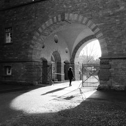 Rear view of woman walking in archway