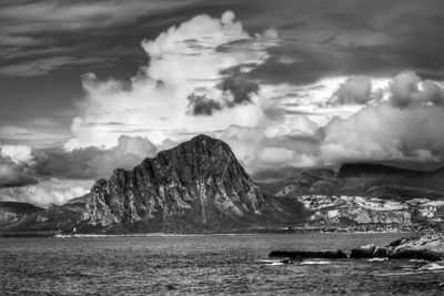 Scenic view of sea and mountains against sky