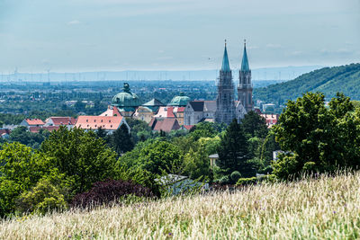 Panoramic view of trees and buildings against sky