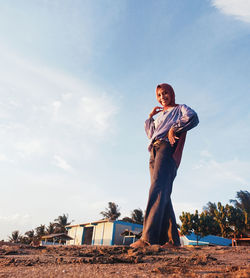 Full length of woman standing on beach against sky