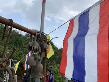 Multi colored flags hanging on land against sky