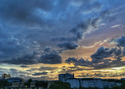 Low angle view of buildings against dramatic sky