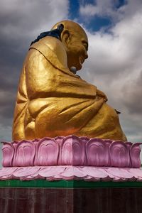 Low angle view of statue against temple against sky